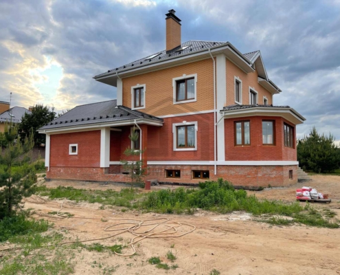 Вид дома справа дома с цокольным этажом и гаражом в Нахабино
