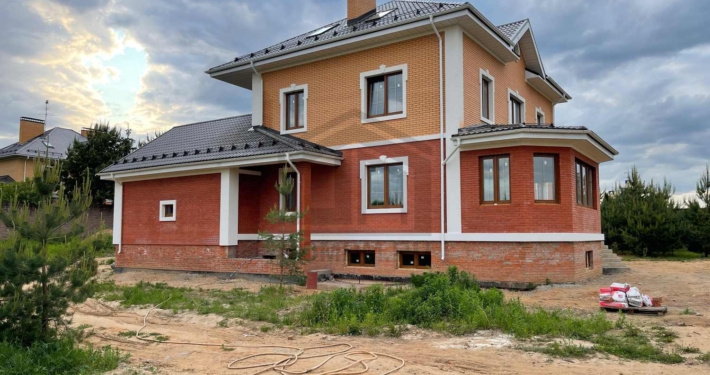 Вид дома справа дома с цокольным этажом и гаражом в Нахабино