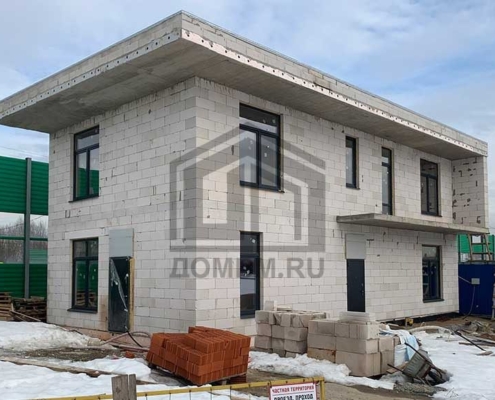 Боковой фасад дома в стиле хай-тек площадью 199 м2 зимой