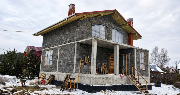 Фасад дома зимой дома с бассейном в Долгопрудном
