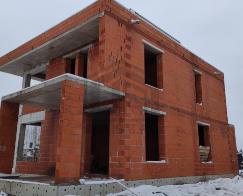 Фасад построенного дома слева двухэтажного дома с плоской крышей в Химках