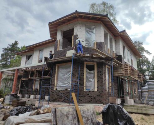 Облицовка фасада коттеджа кирпичом на строительных лесах, Балашиха